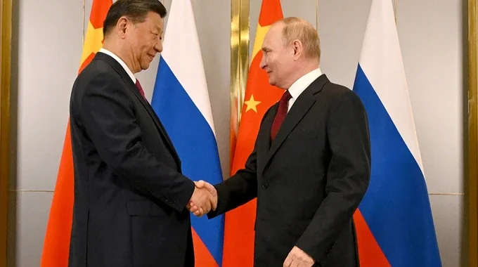 Владимир Путин и Си Цзиньпин жмут руки во время встречи в Китае