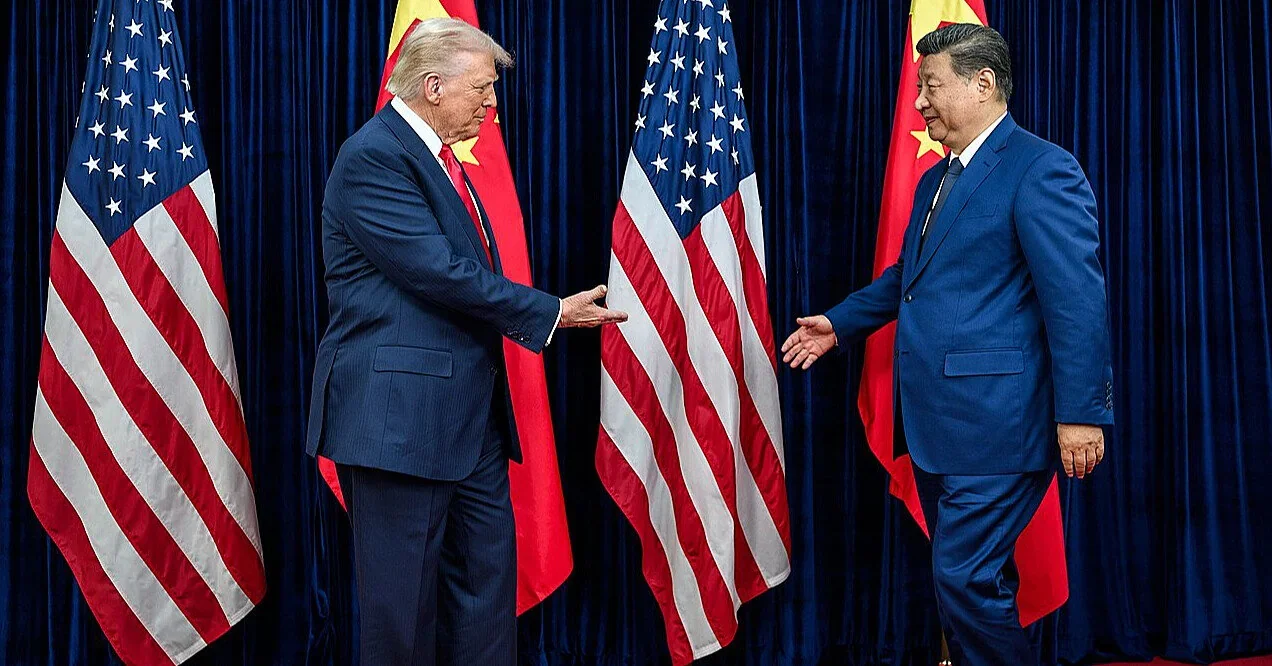 Дональд Трамп и Си Цзиньпин жмут руки на фоне флагов США и Китая