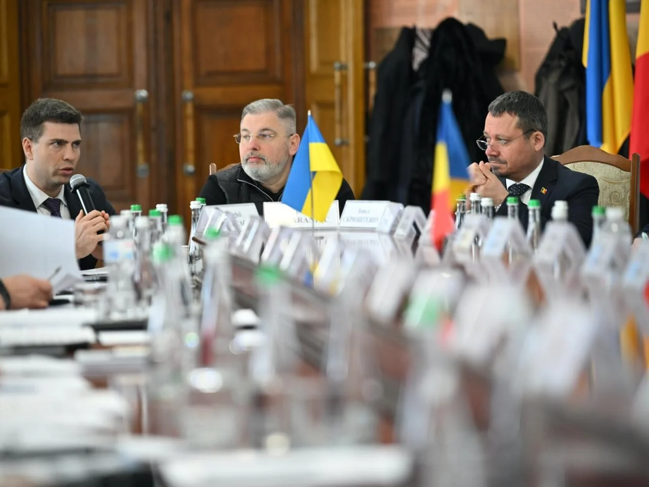 Учасники діалогу Україна-Румунія за столом переговорів з прапорами