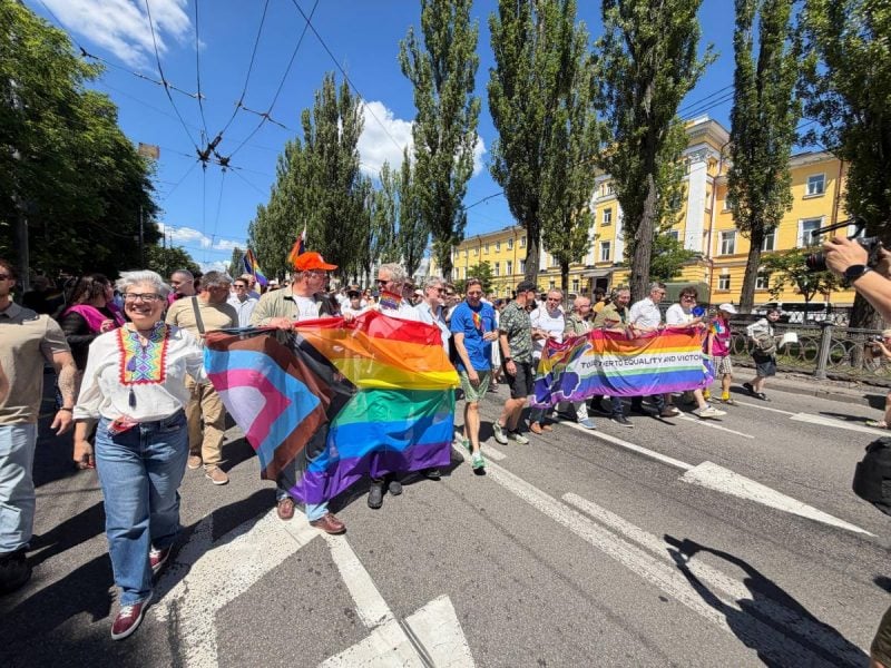 Учасники Маршу КиївПрайд несуть прапор ЛГБТІК+ вулицями Києва
