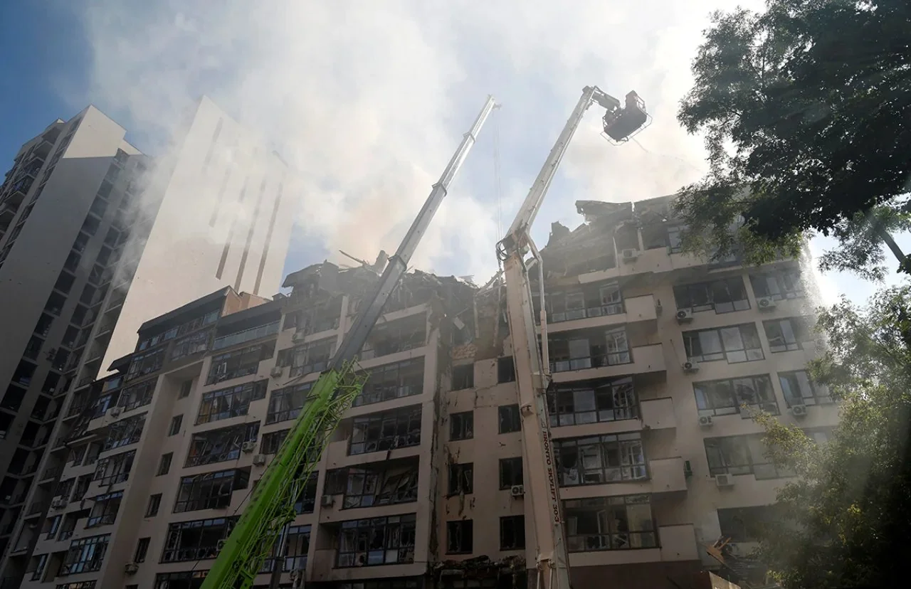 Пошкоджений будинок у Києві після удару з рятувальними кранами