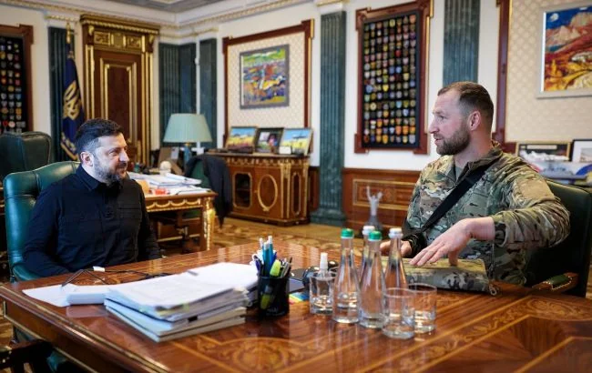 Зеленський і чоловік у камуфляжі сидять за столом у кабінеті