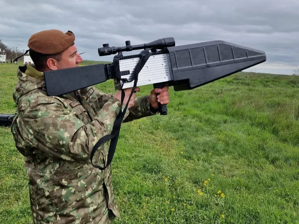 Військовий демонструє протидронову систему новітньої зброї на відкритому полі