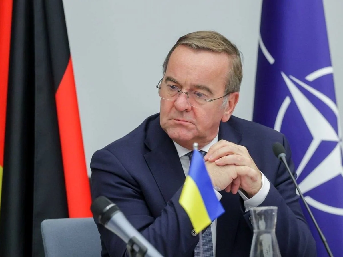 Борис Пісторіус з прапором України на тлі прапорів Німеччини та НАТО