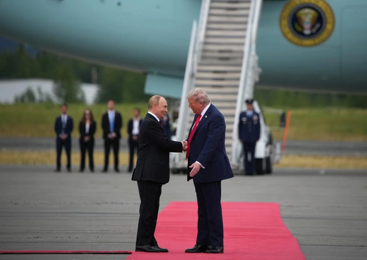 Путін і Трамп тиснуть руки на червоній доріжці біля літака